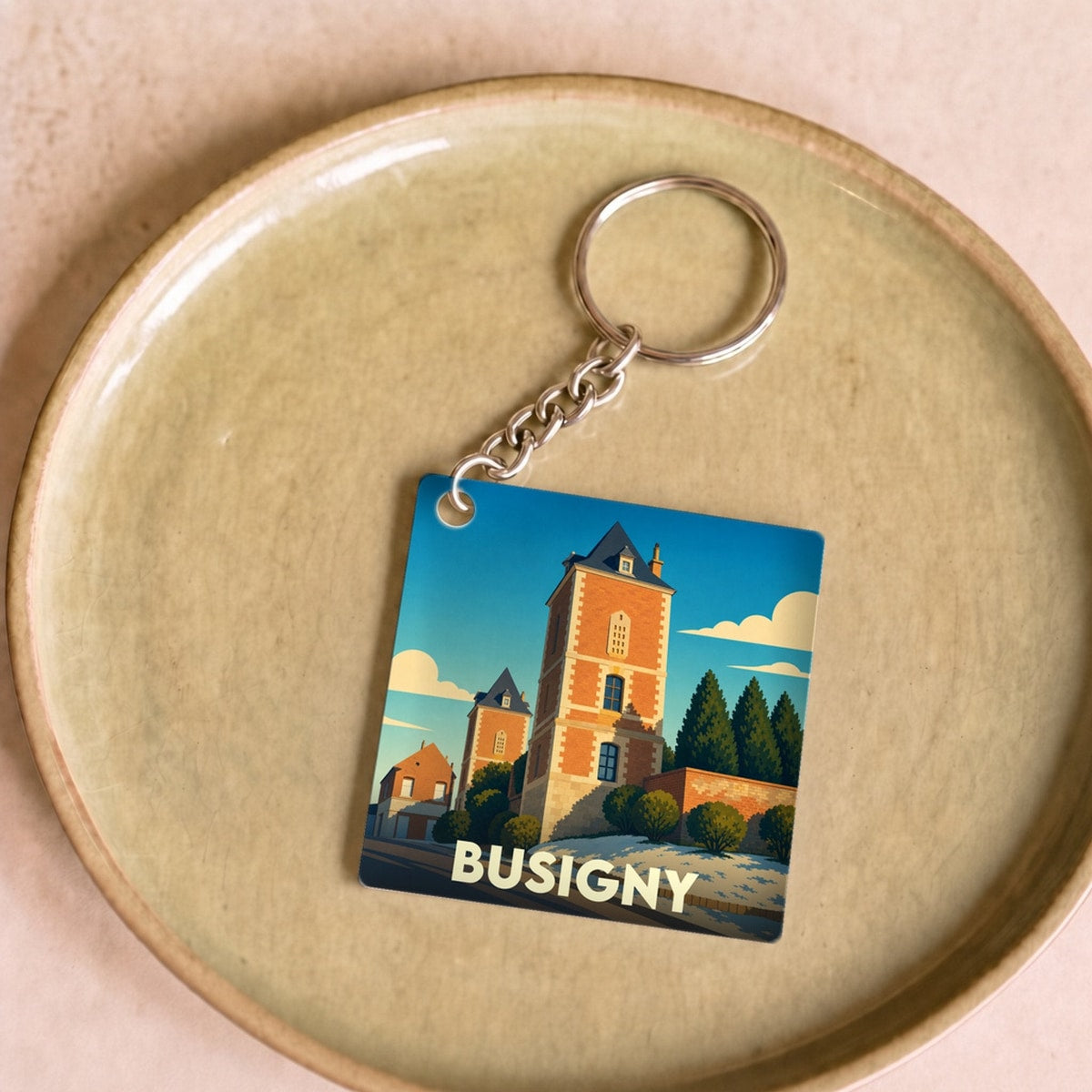 Porte-clés souvenir de la ville de Busigny avec une illustration stylisée.