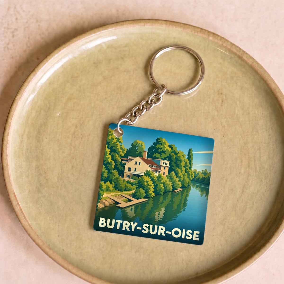 Porte-clés souvenir de la ville de Butry-sur-Oise avec une illustration stylisée des bords de l'Oise.