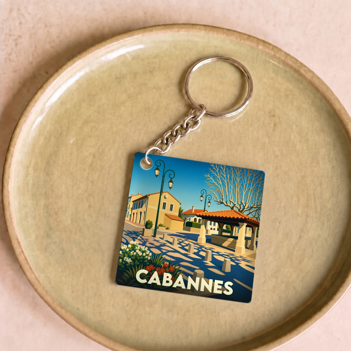 Porte-clés souvenir de la ville de Cabannes avec une illustration stylisée et colorée.