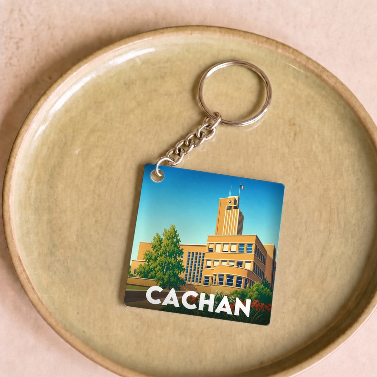 Porte-clés souvenir de la ville de Cachan avec une illustration stylisée de son hôtel de ville.