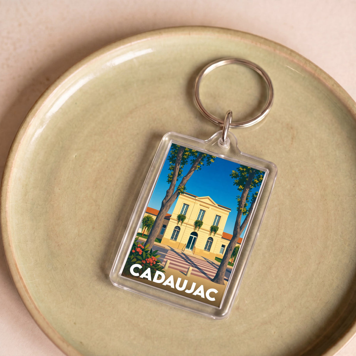 Porte-clés souvenir de la ville de Cadaujac avec une illustration stylisée.