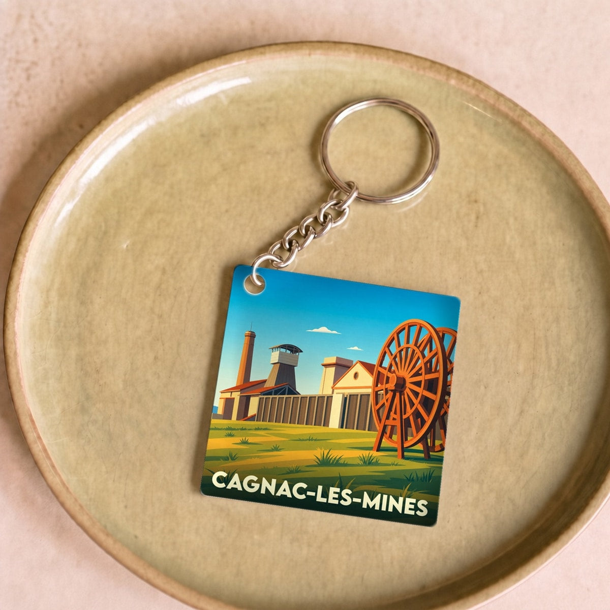 Porte-clés souvenir de la ville de Cagnac-les-Mines avec une illustration stylisée de son patrimoine minier.