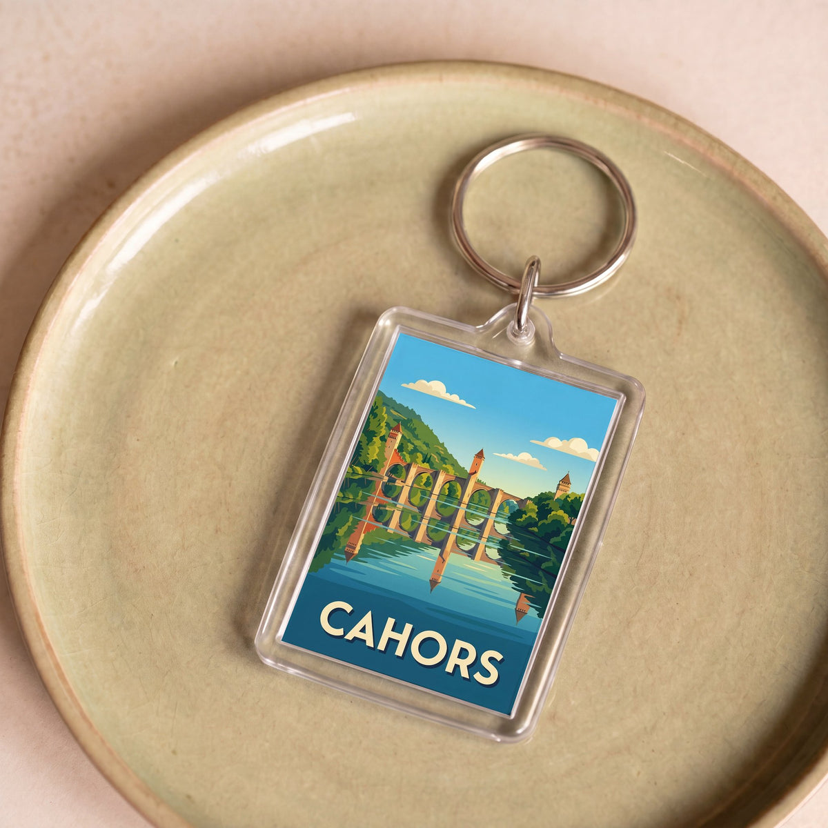 Porte-clés souvenir de la ville de Cahors avec une illustration stylisée.