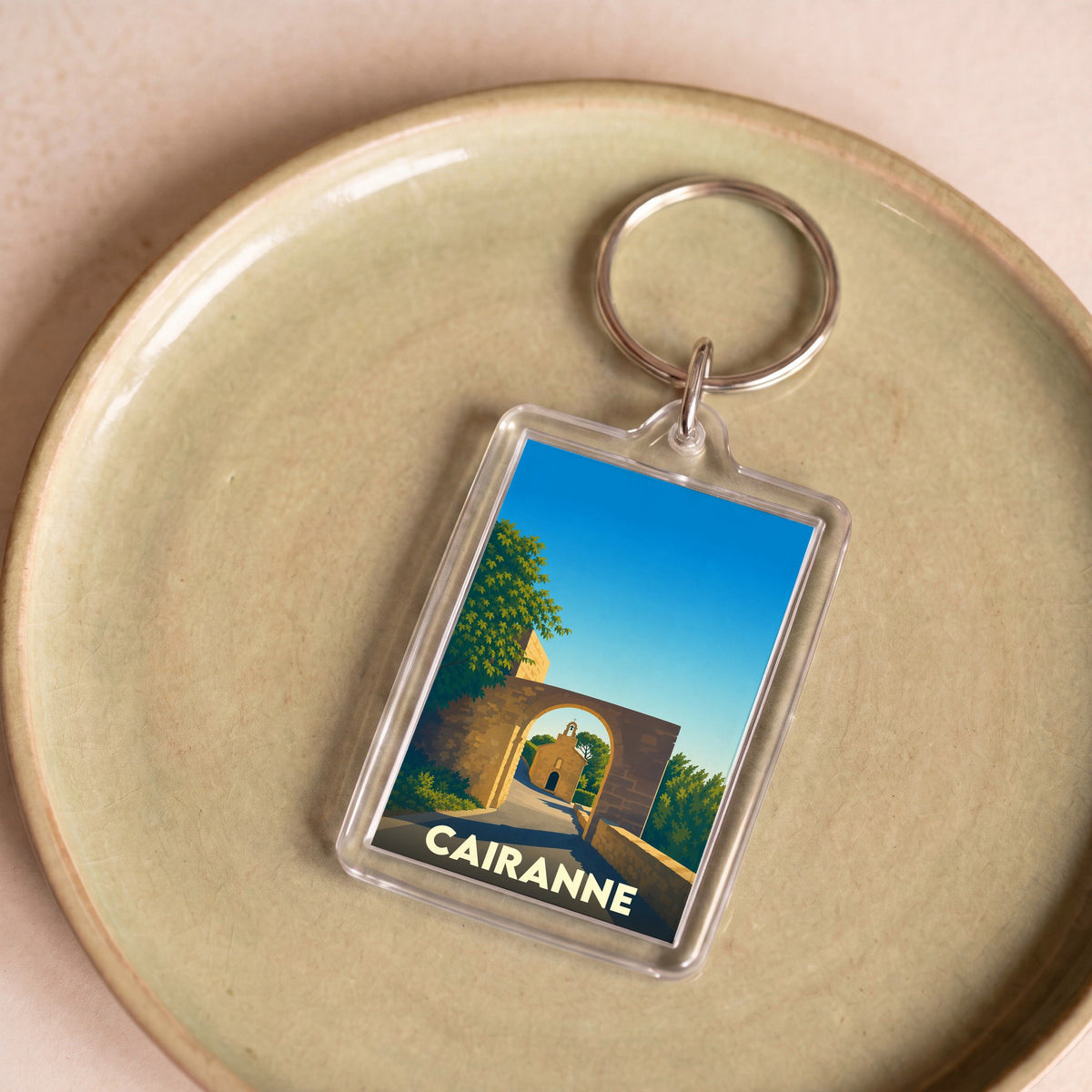 Porte-clés souvenir de la ville de Cairanne avec une illustration stylisée.