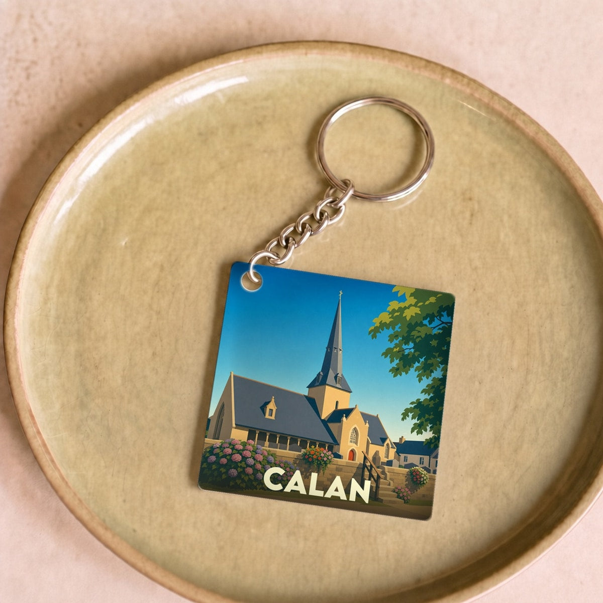 Porte-clés souvenir de la ville de Calan illustrant son église dans un style graphique épuré.