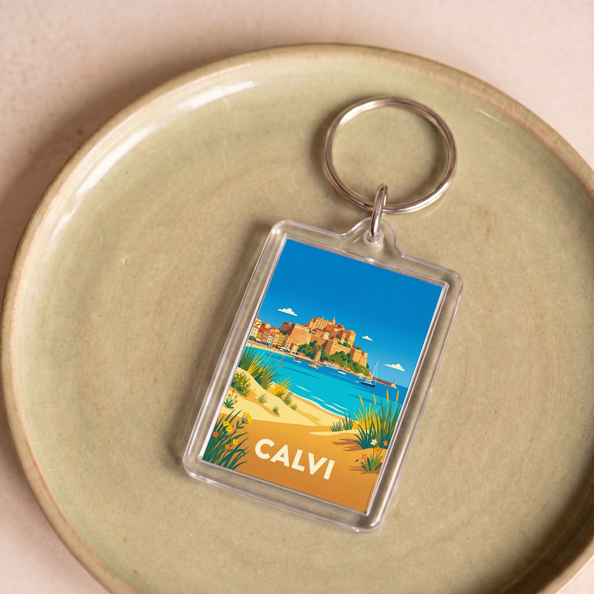 Porte-clés souvenir de la ville de Calvi avec une illustration stylisée de son paysage côtier.
