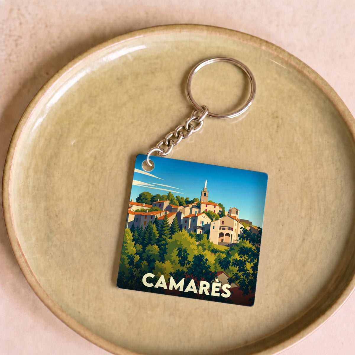 Porte-clés souvenir de la ville de Camarès avec une illustration stylisée.