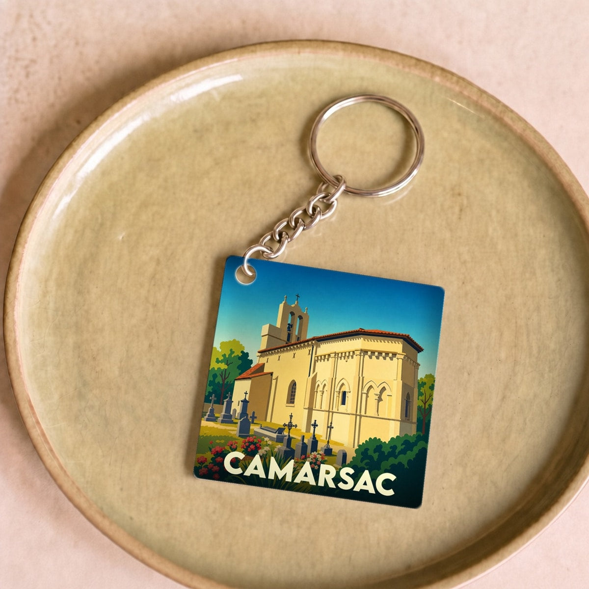 Porte-clés souvenir de la ville de Camarsac avec une illustration stylisée de son église.