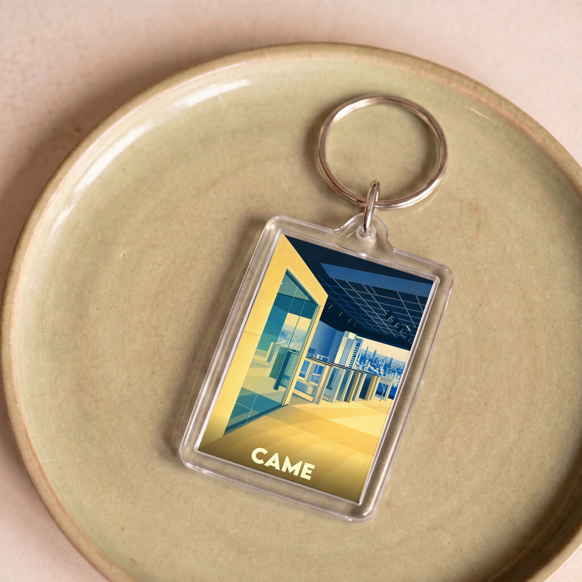 Porte-clés souvenir de la ville de Came avec une illustration urbaine stylisée.