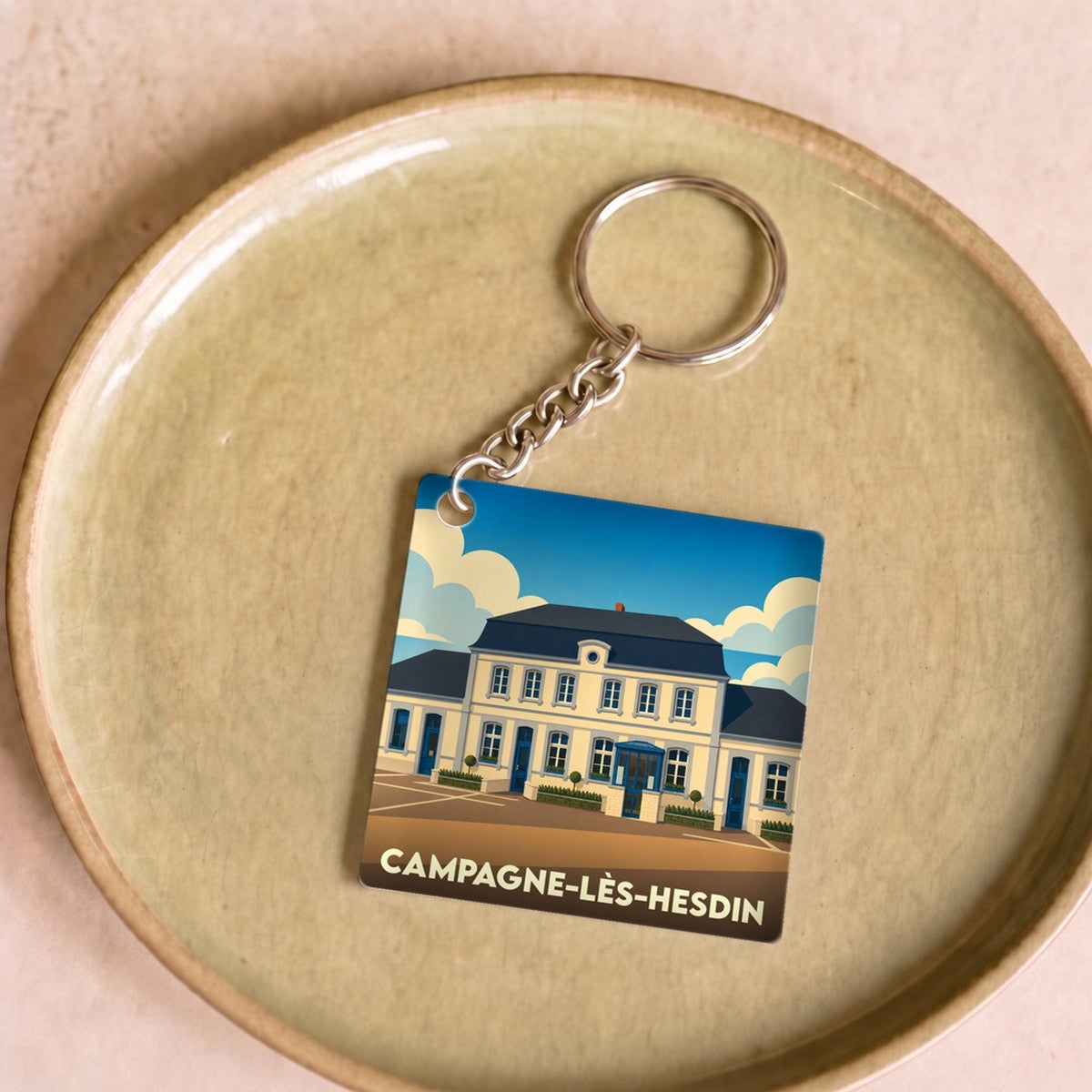 Porte-clés souvenir de la ville de Campagne-lès-Hesdin avec une illustration stylisée.
