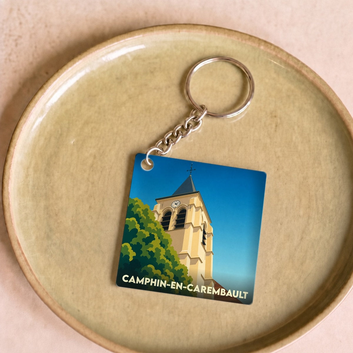 Porte-clés souvenir de la ville de Camphin-en-Carembault avec une illustration stylisée de son clocher.