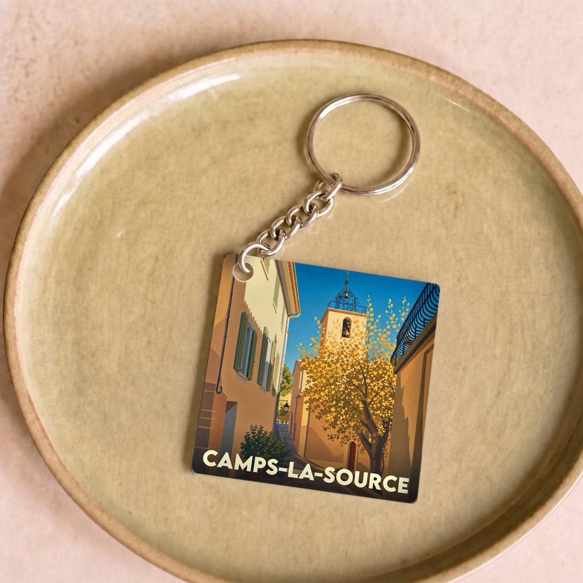 Porte-clés souvenir de la ville de Camps-la-Source avec une illustration stylisée d'une ruelle provençale.