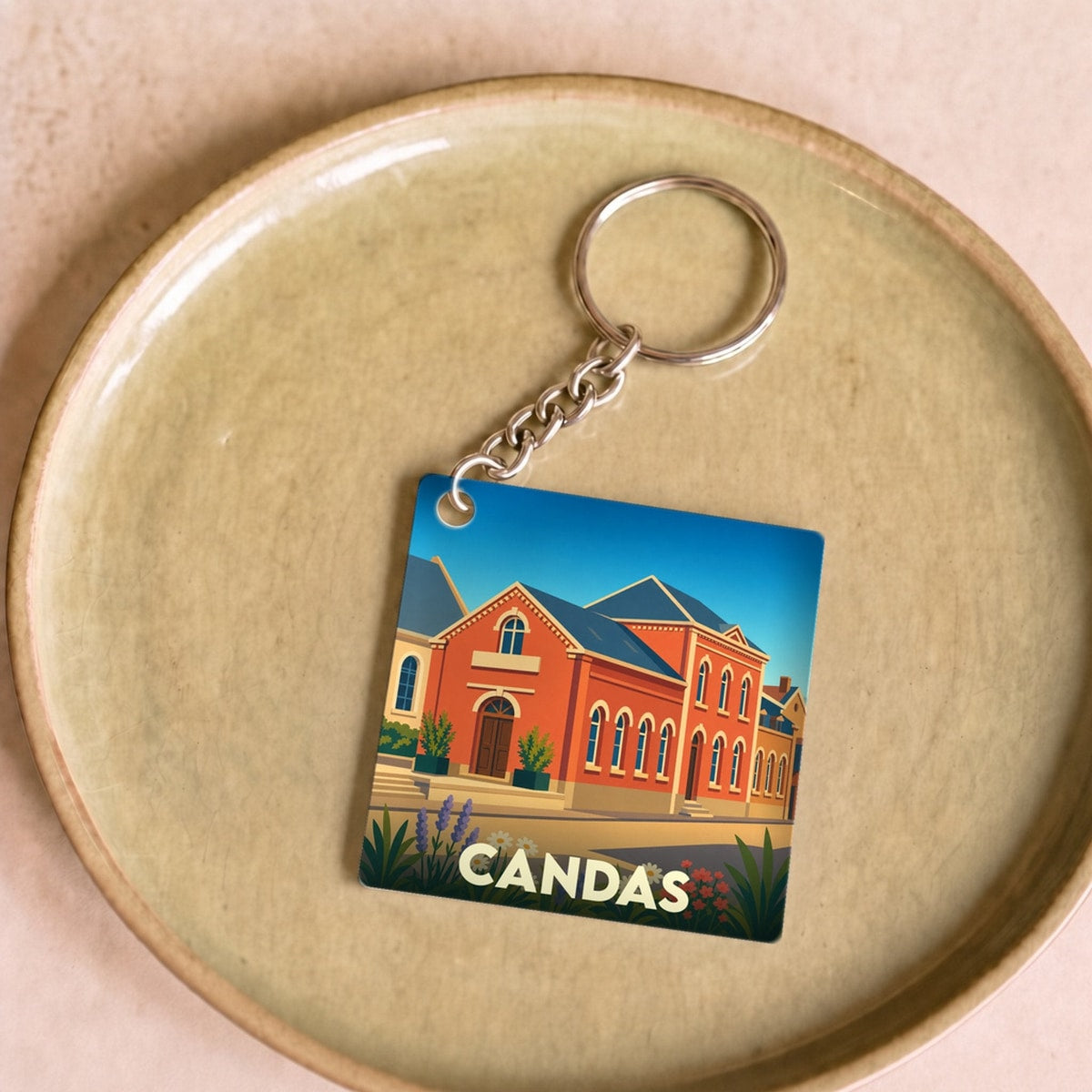 Porte-clés souvenir de la ville de Candas avec une illustration stylisée.