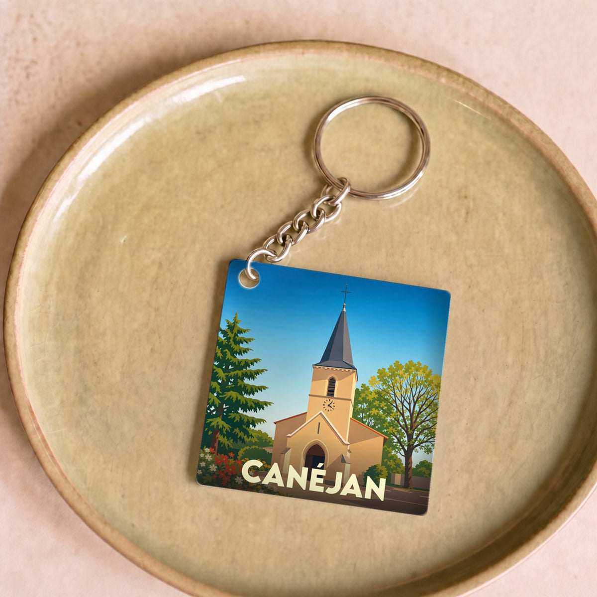 Porte-clés souvenir de la ville de Canéjan avec une illustration stylisée de son église.