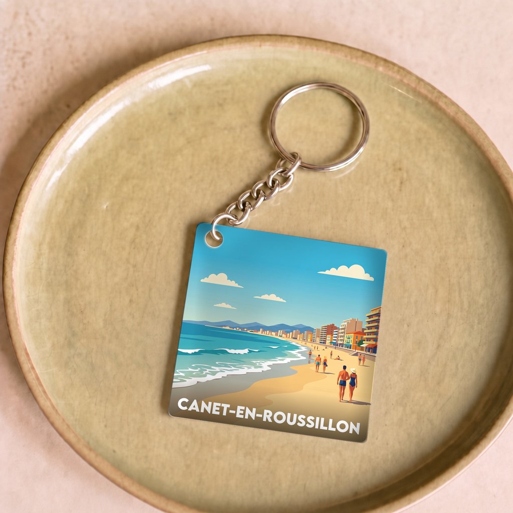 Porte-clés souvenir de la ville de Canet-en-Roussillon avec une illustration de plage stylisée.