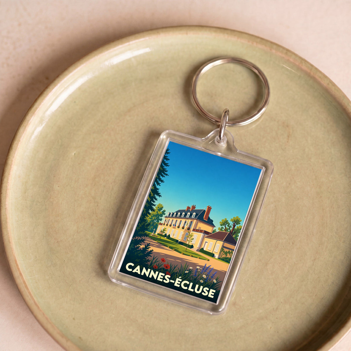 Porte-clés souvenir de la ville de Cannes-Écluse avec une illustration stylisée.