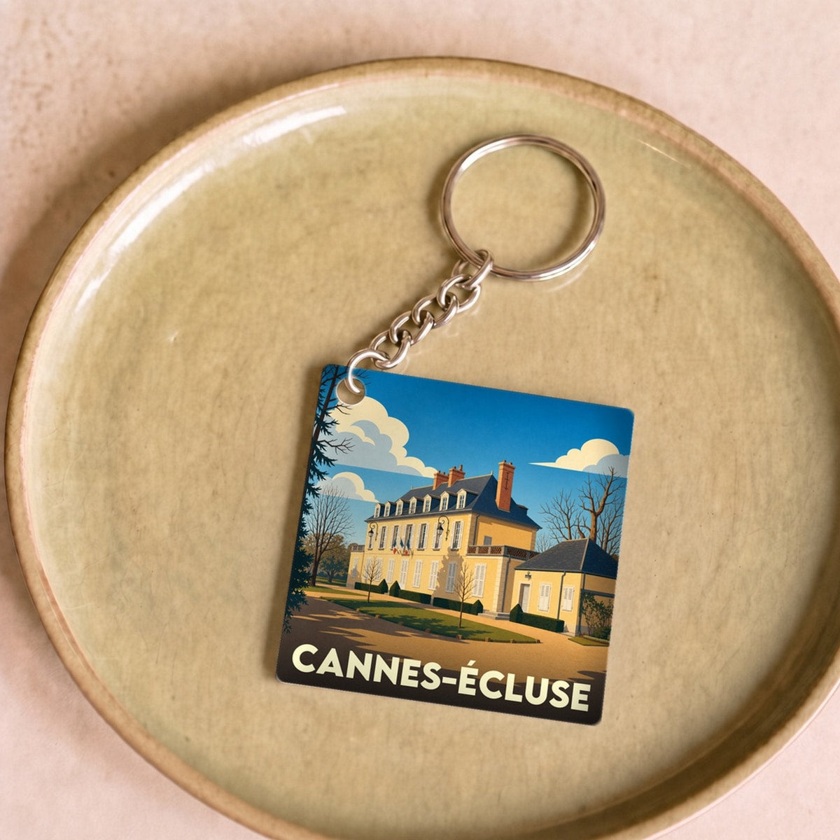 Porte-clés souvenir de la ville de Cannes-Écluse avec une illustration stylisée.