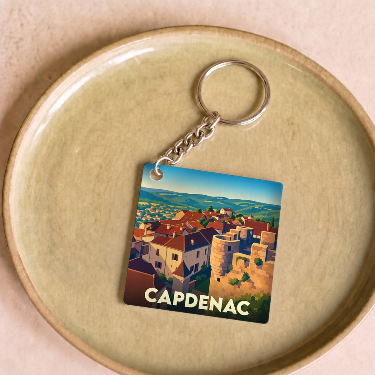 Porte-clés souvenir de la ville de Capdenac avec une illustration stylisée.