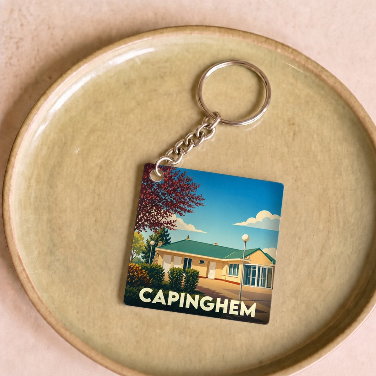 Porte-clés souvenir de la ville de Capinghem avec une illustration stylisée.