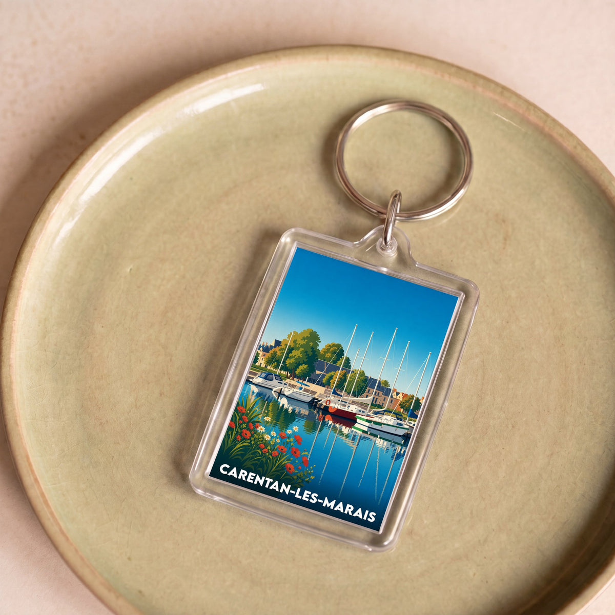Porte-clés souvenir de la ville de Carentan-les-Marais avec une illustration stylisée de son port.