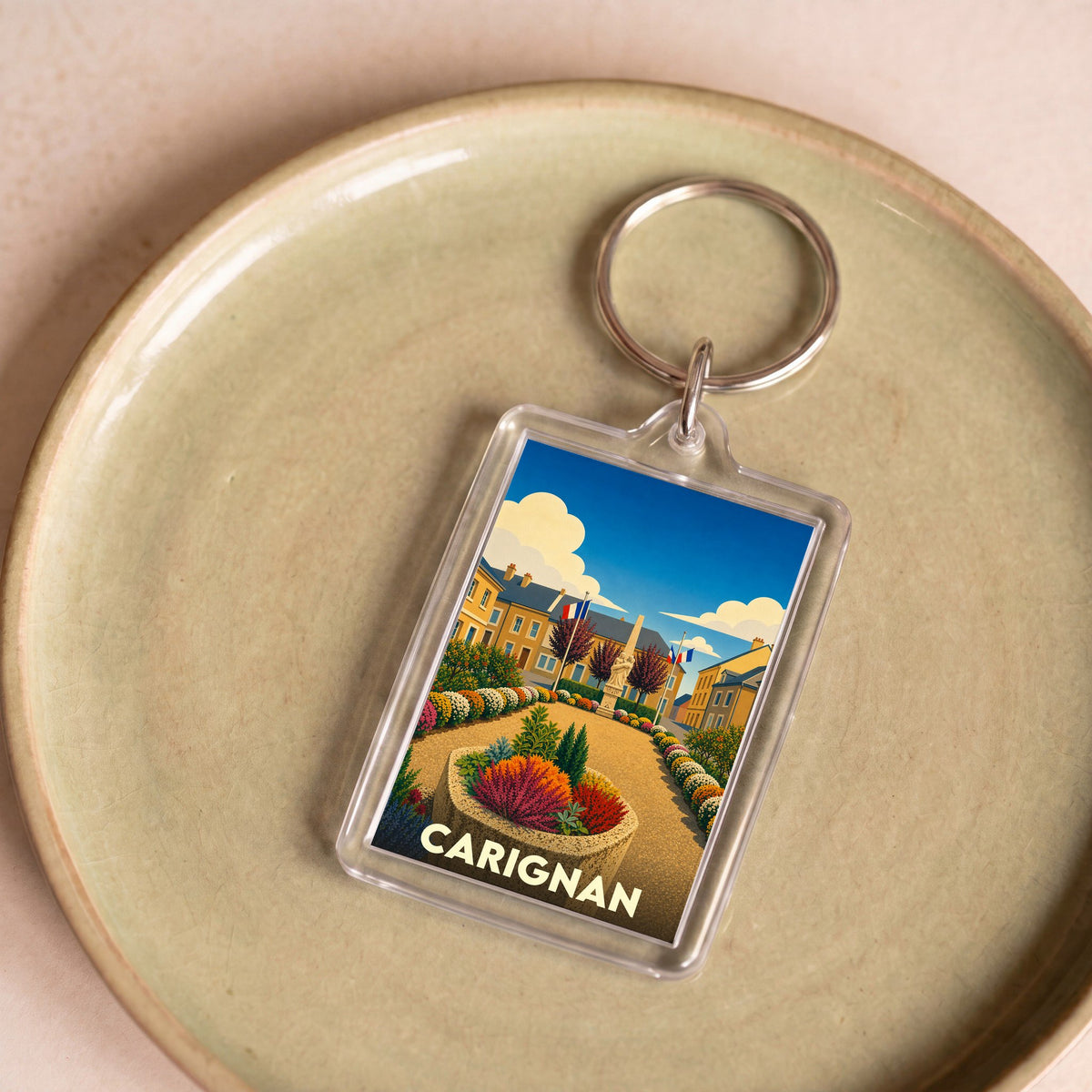 Porte-clés souvenir de la ville de Carignan avec une illustration colorée et stylisée.