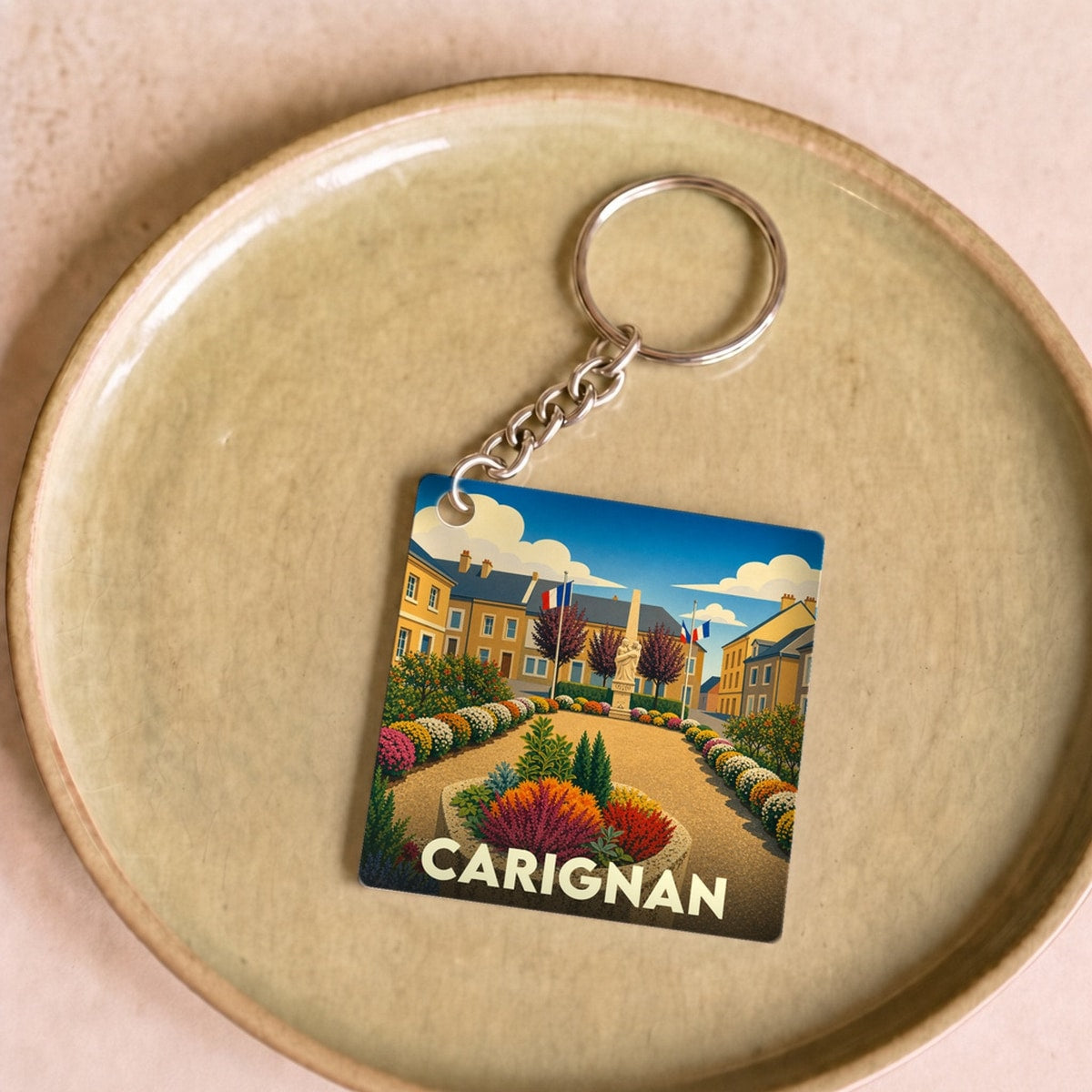 Porte-clés souvenir de la ville de Carignan avec une illustration colorée et stylisée.