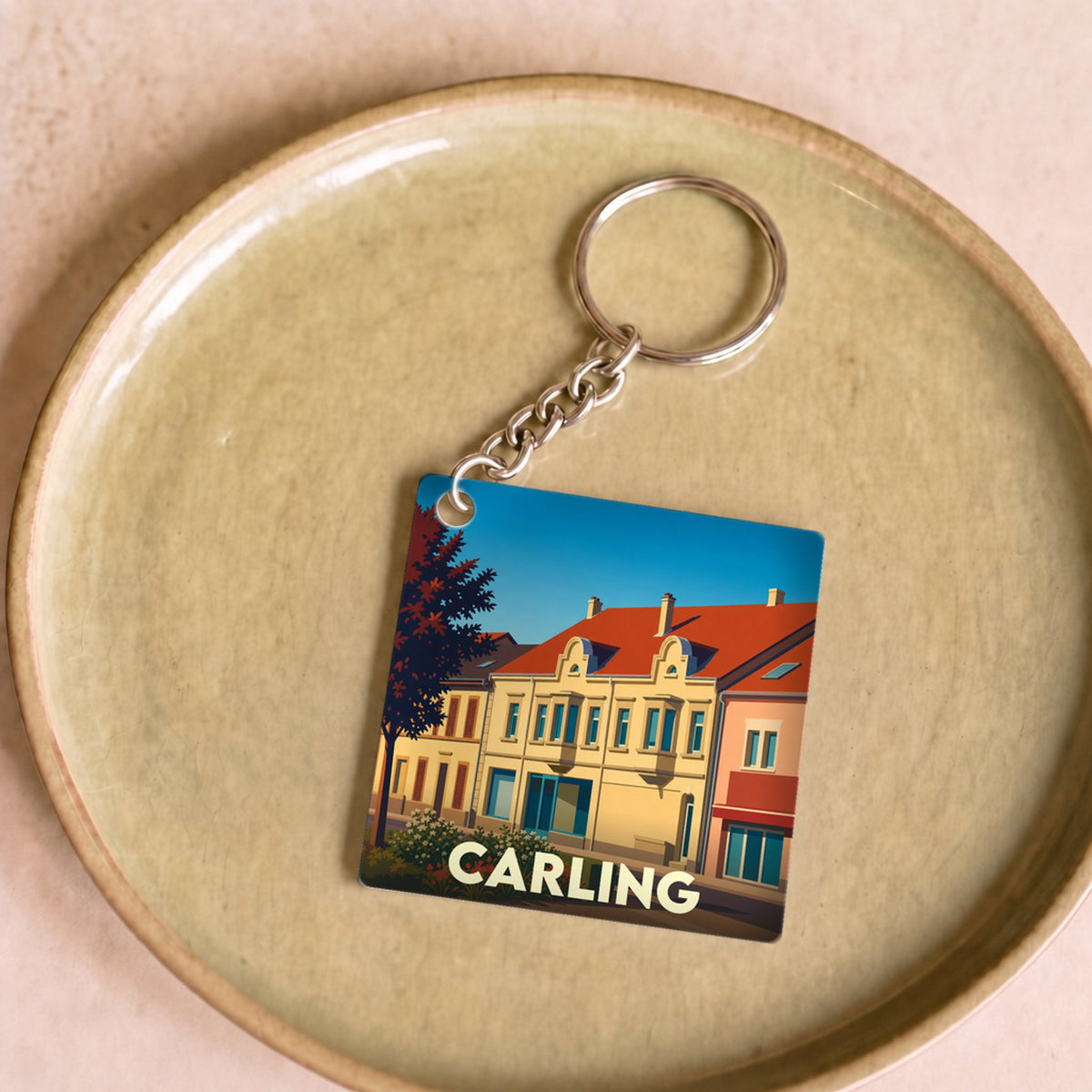 Porte-clés souvenir de la ville de Carling avec une illustration stylisée.