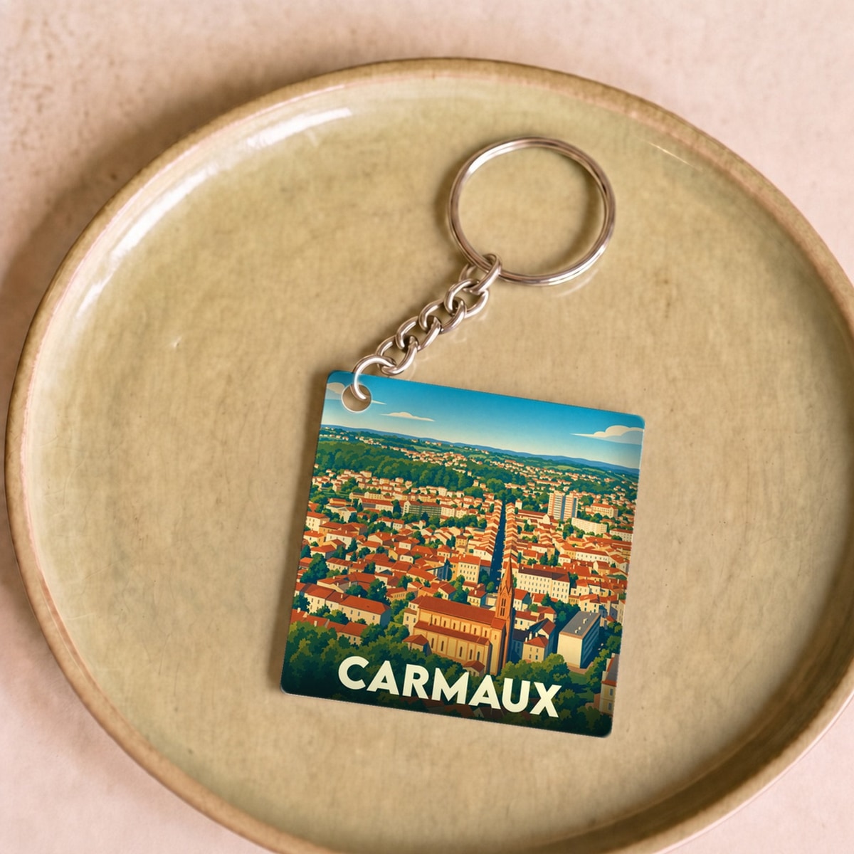 Porte-clés souvenir de la ville de Carmaux avec une illustration panoramique stylisée.