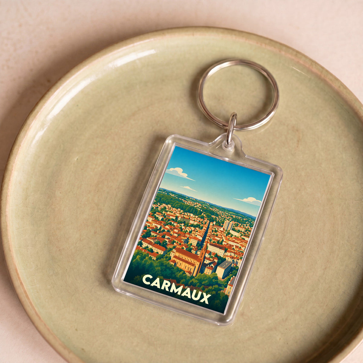 Porte-clés souvenir de la ville de Carmaux avec une illustration panoramique stylisée.