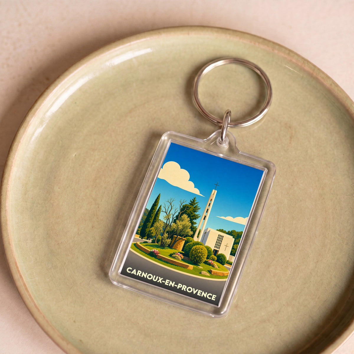 Porte-clés souvenir de la ville de Carnoux-en-Provence avec une illustration stylisée.