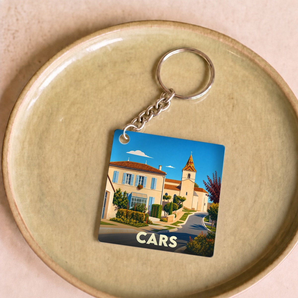 Porte-clés souvenir de la ville de Cars avec une illustration stylisée d'un paysage urbain.