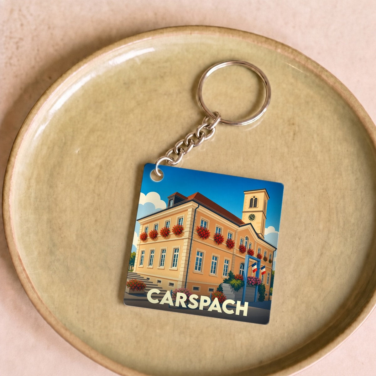Porte-clés souvenir de la ville de Carspach avec une illustration stylisée de sa mairie.
