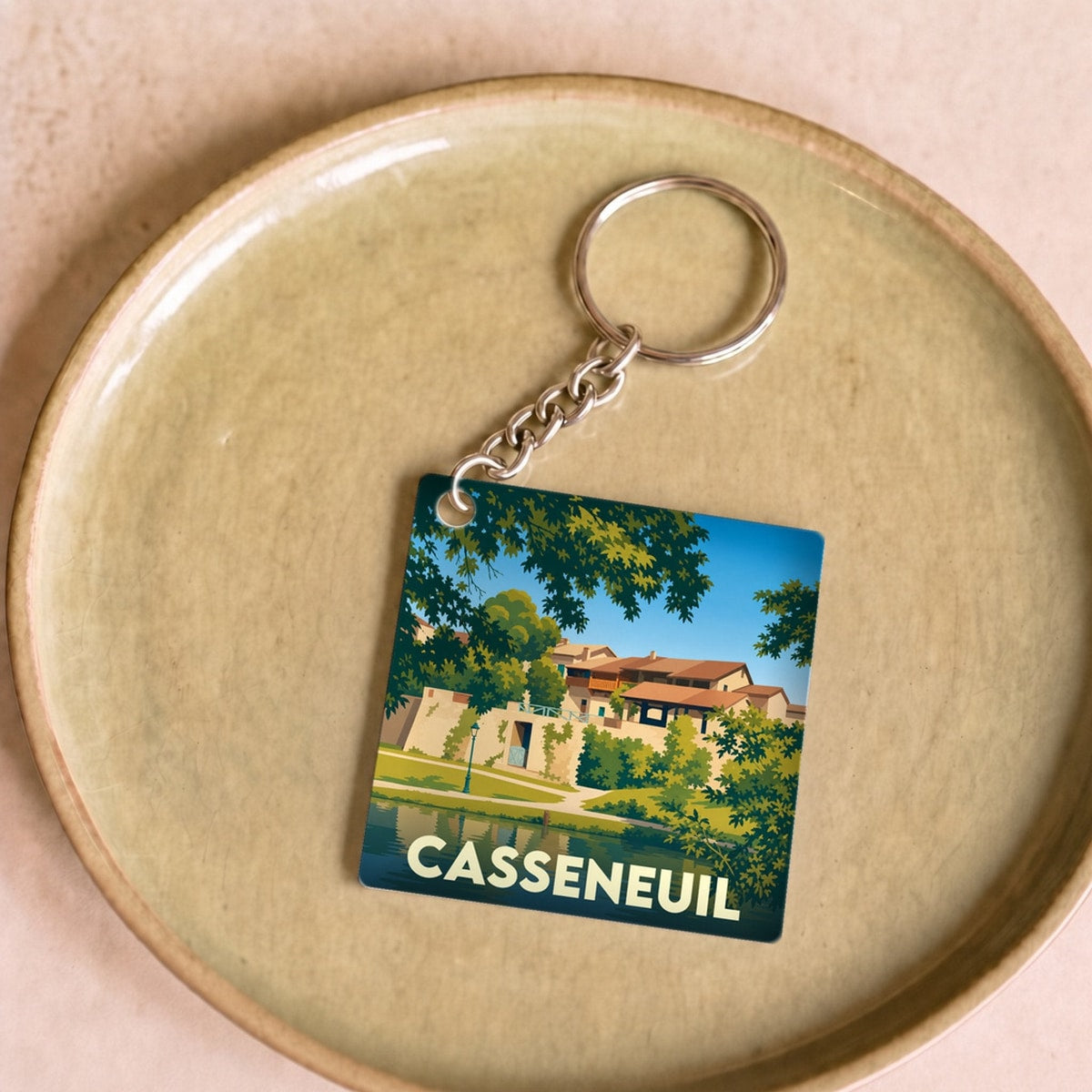Porte-clés souvenir de la ville de Casseneuil avec une illustration stylisée.