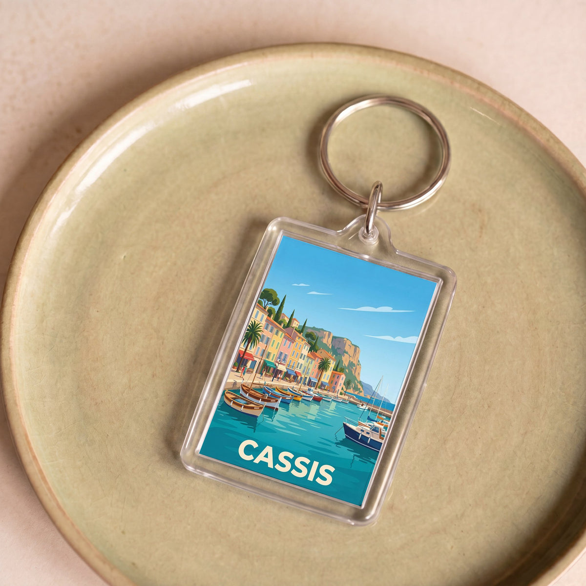Porte-clés souvenir de la ville de Cassis avec une illustration stylisée.