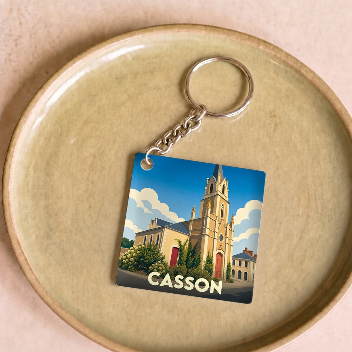 Porte-clés souvenir de la ville de Casson avec une illustration stylisée de son église.
