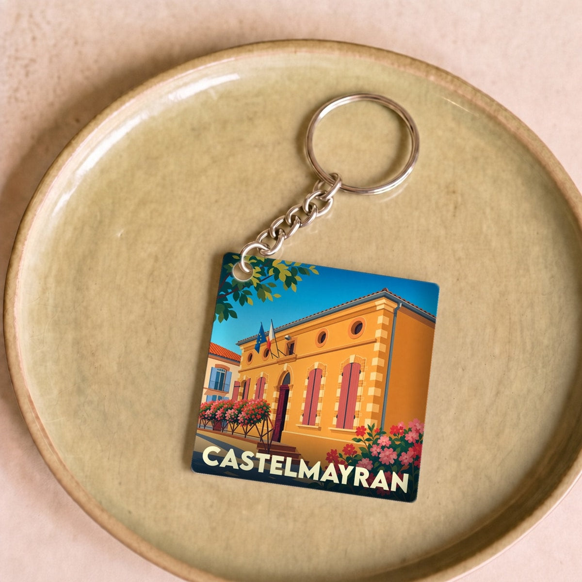 Porte-clés souvenir de la ville de Castelmayran avec une illustration stylisée de sa mairie.