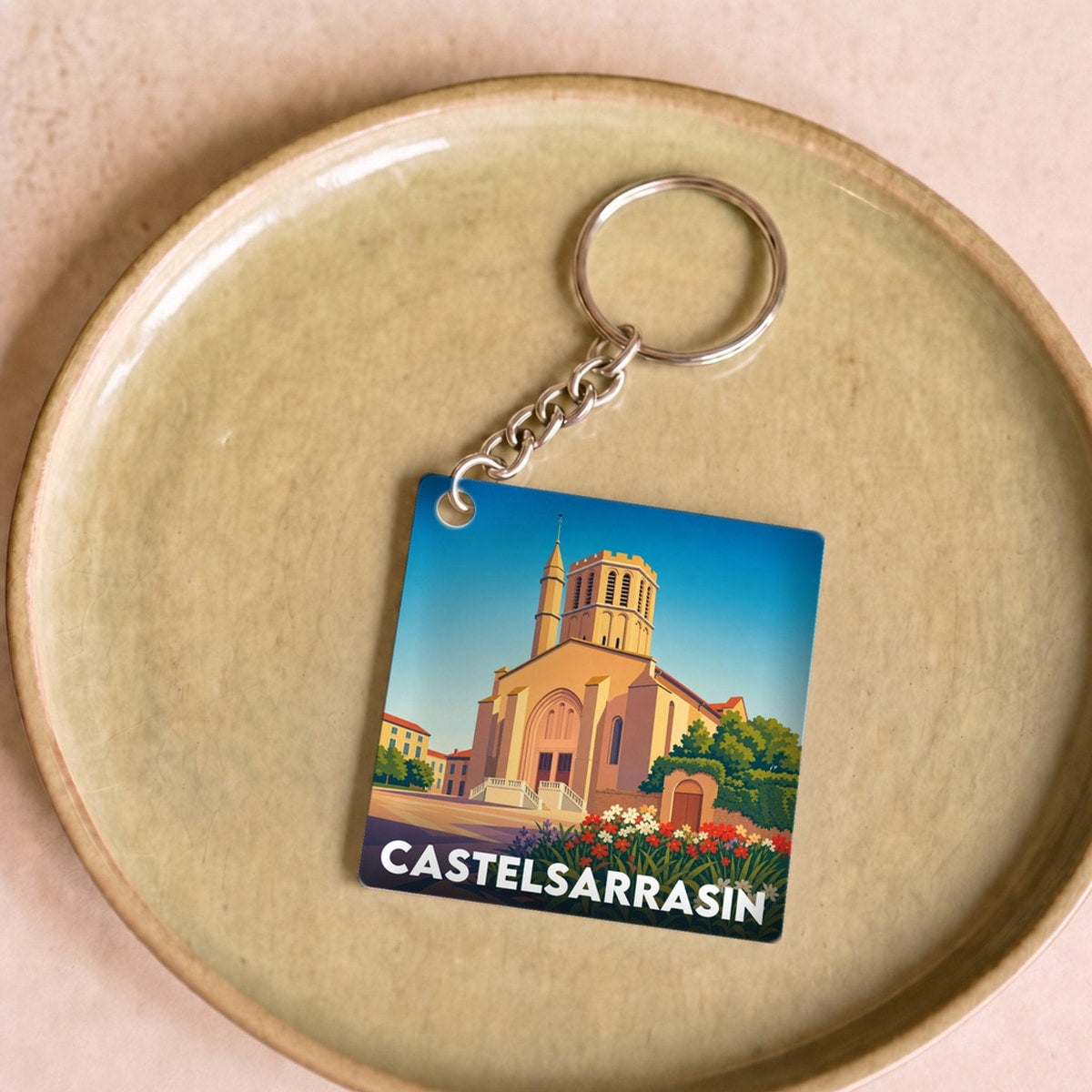 Porte-clés souvenir de la ville de Castelsarrasin avec une illustration graphique stylisée.
