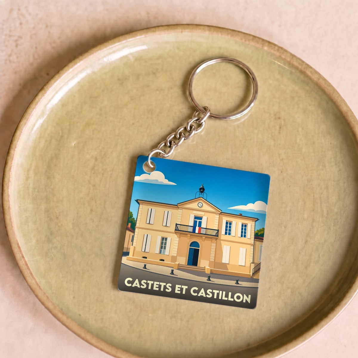 Porte-clés souvenir de la commune de Castets et Castillon avec une illustration stylisée de la mairie.