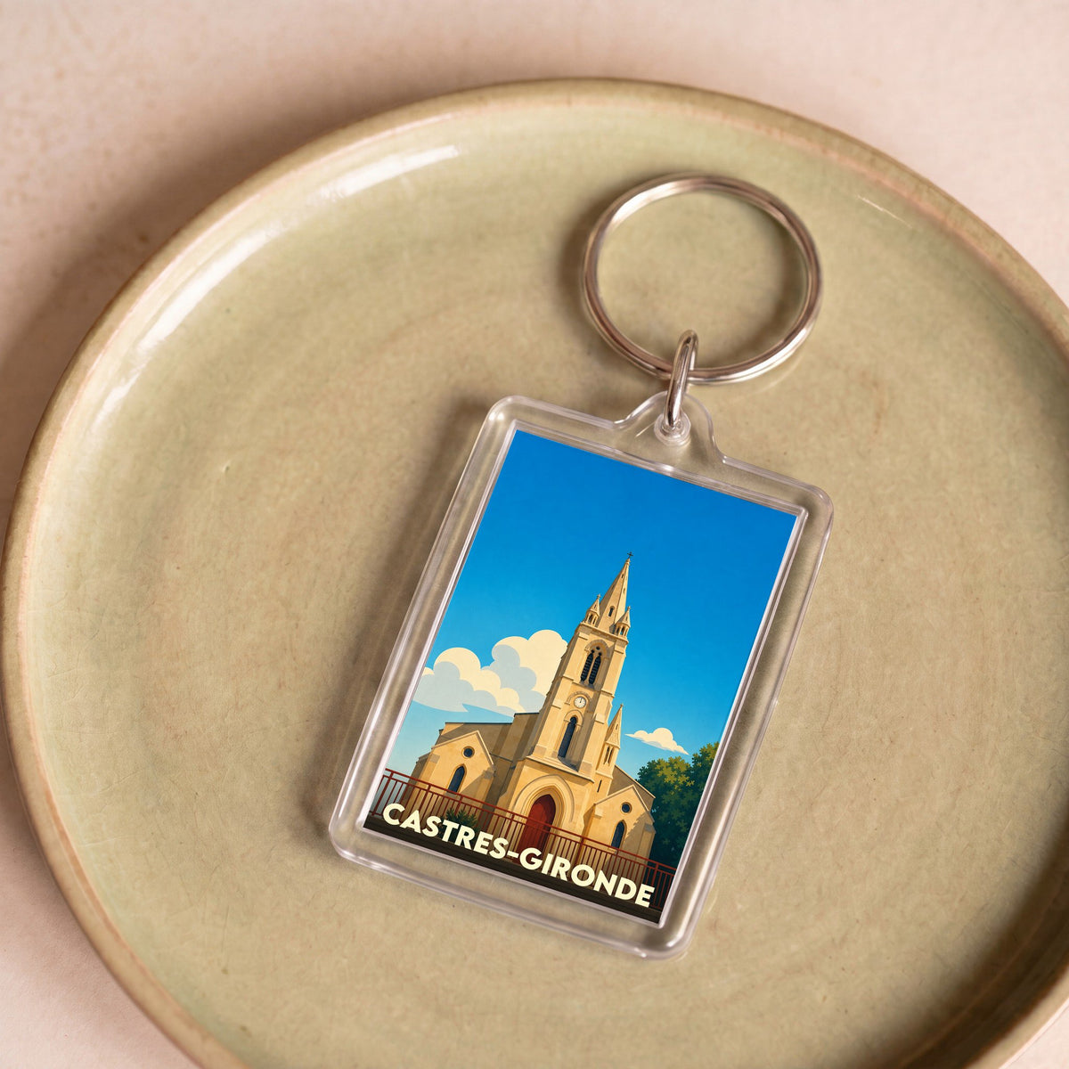 Porte-clés souvenir de la ville de Castres-Gironde avec une illustration stylisée de son église.