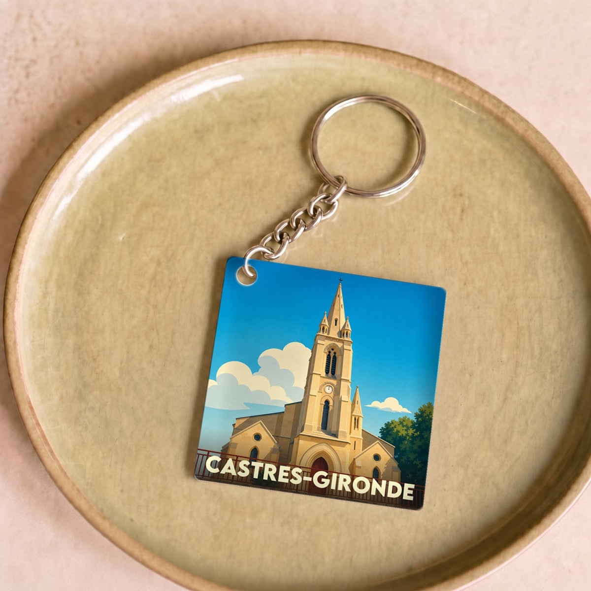 Porte-clés souvenir de la ville de Castres-Gironde avec une illustration stylisée de son église.