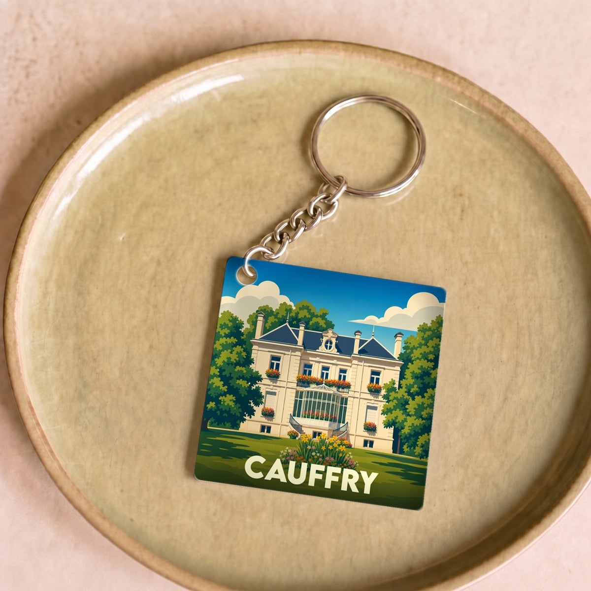 Porte-clés souvenir de la ville de Cauffry avec une illustration stylisée d'un manoir.