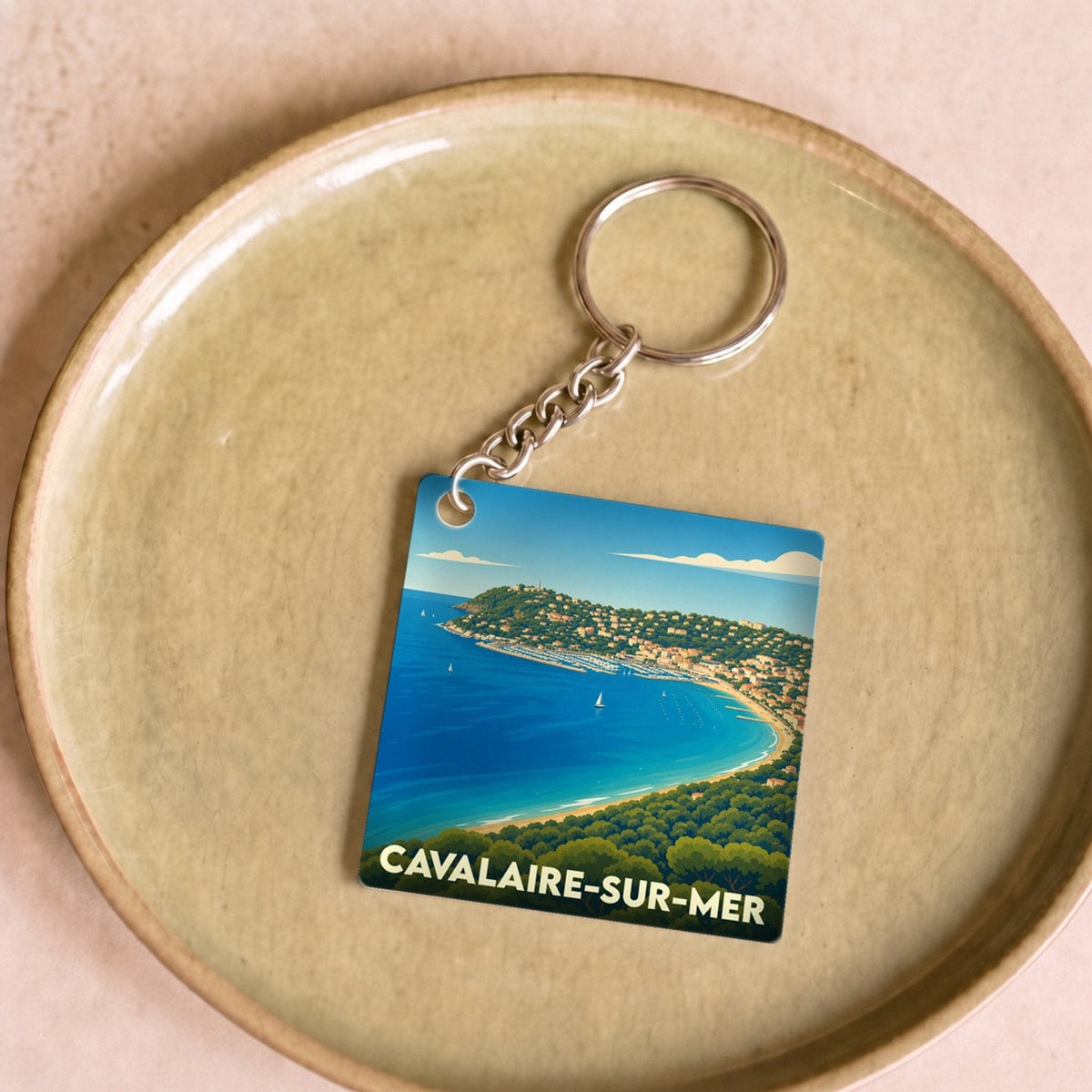 Porte-clés souvenir de la ville de Cavalaire-sur-Mer avec une illustration stylisée de son littoral.