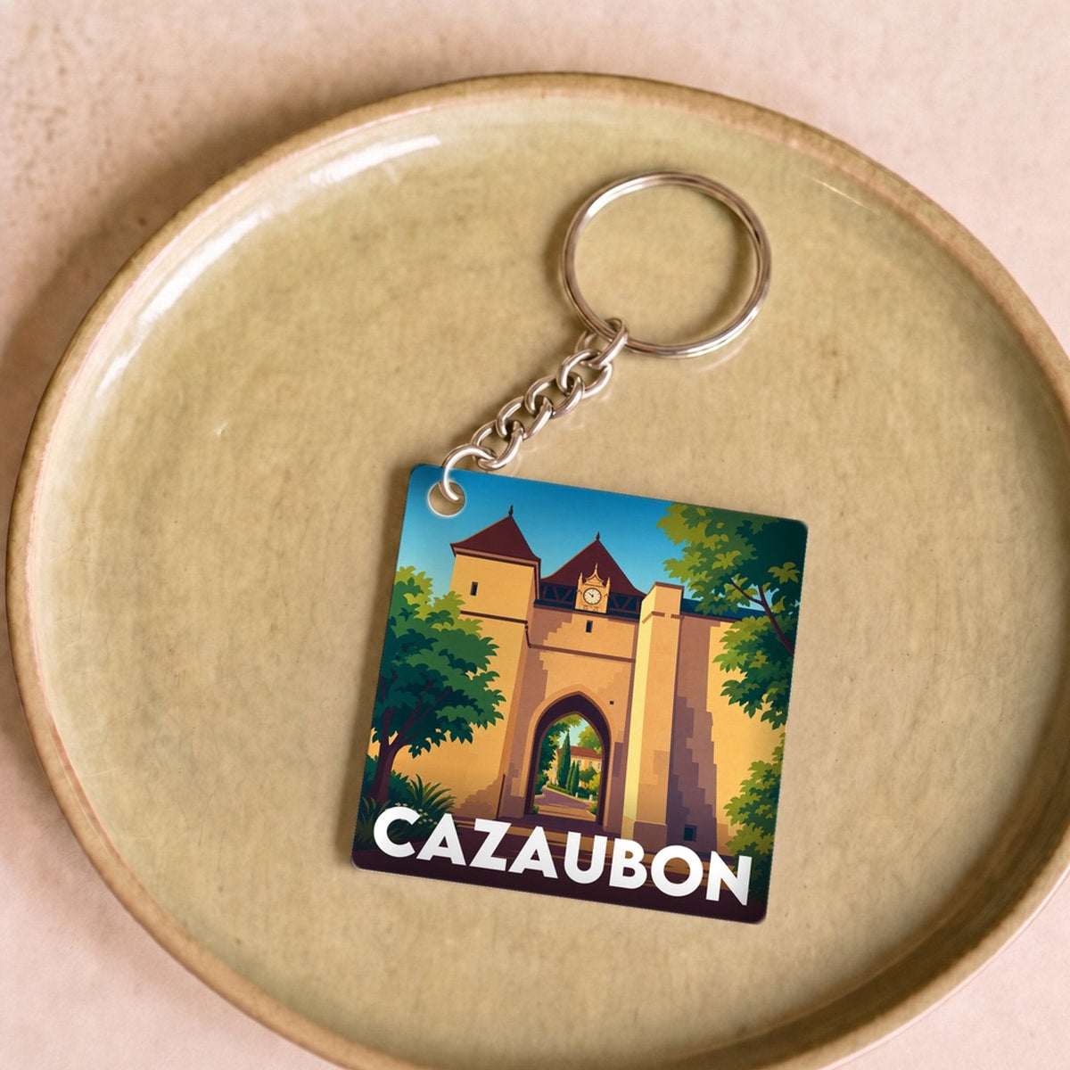 Porte-clés souvenir de la ville de Cazaubon avec une illustration stylisée.