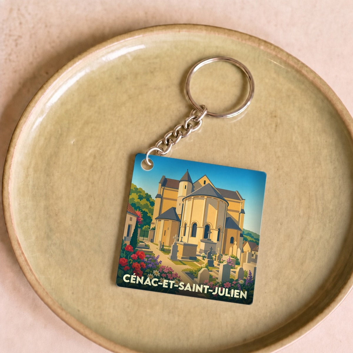 Porte-clés souvenir de la ville de Cénac-et-Saint-Julien avec une illustration stylisée de son église et de ses fleurs.