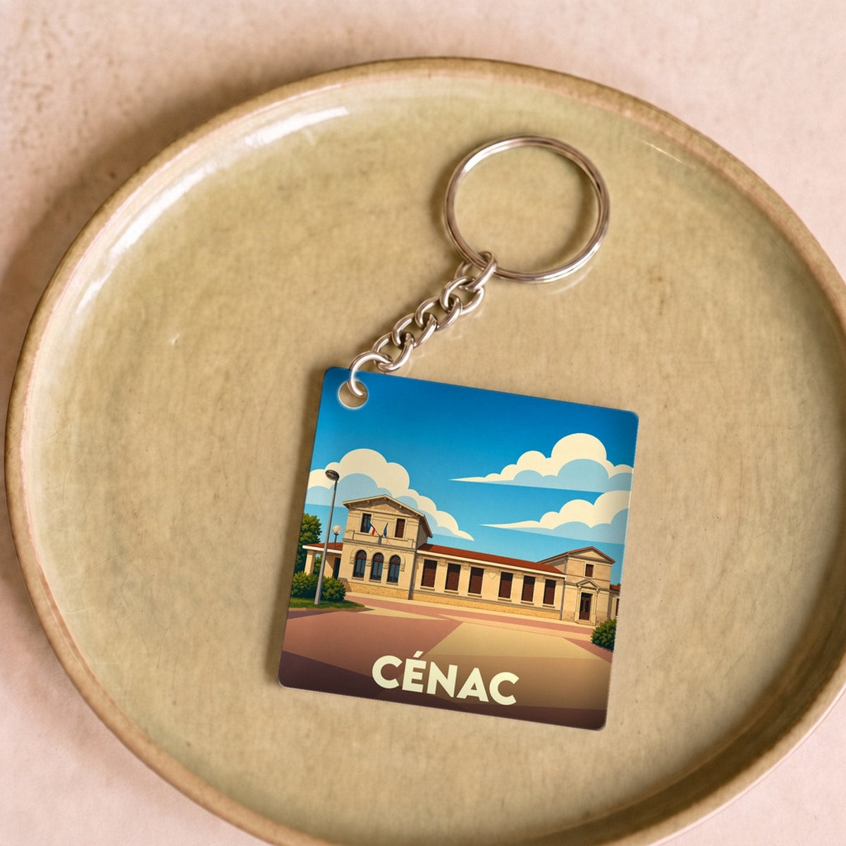 Porte-clés souvenir de la ville de Cénac avec une illustration stylisée.