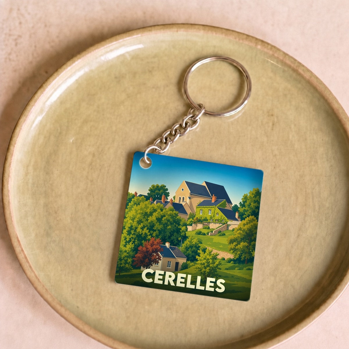 Porte-clés souvenir de la ville de Cerelles avec une illustration stylisée d'un paysage de campagne.