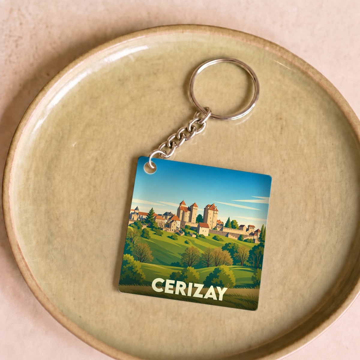 Porte-clés souvenir de la ville de Cerizay avec une illustration stylisée de son paysage et de son château.