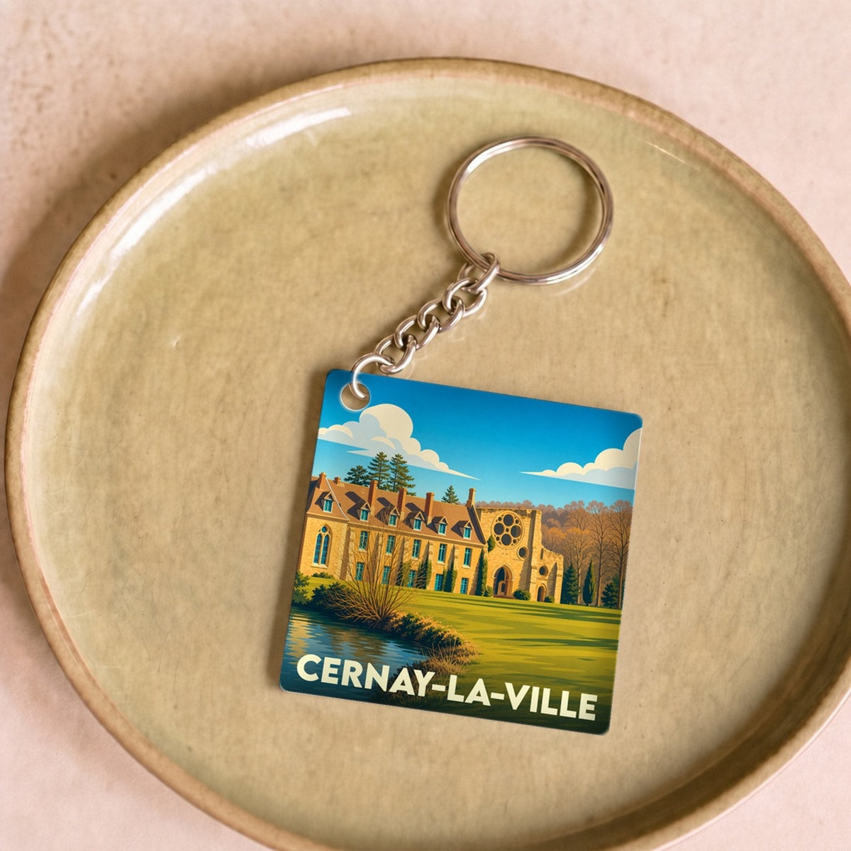 Porte-clés souvenir de la ville de Cernay-la-Ville avec une illustration stylisée de son abbaye.