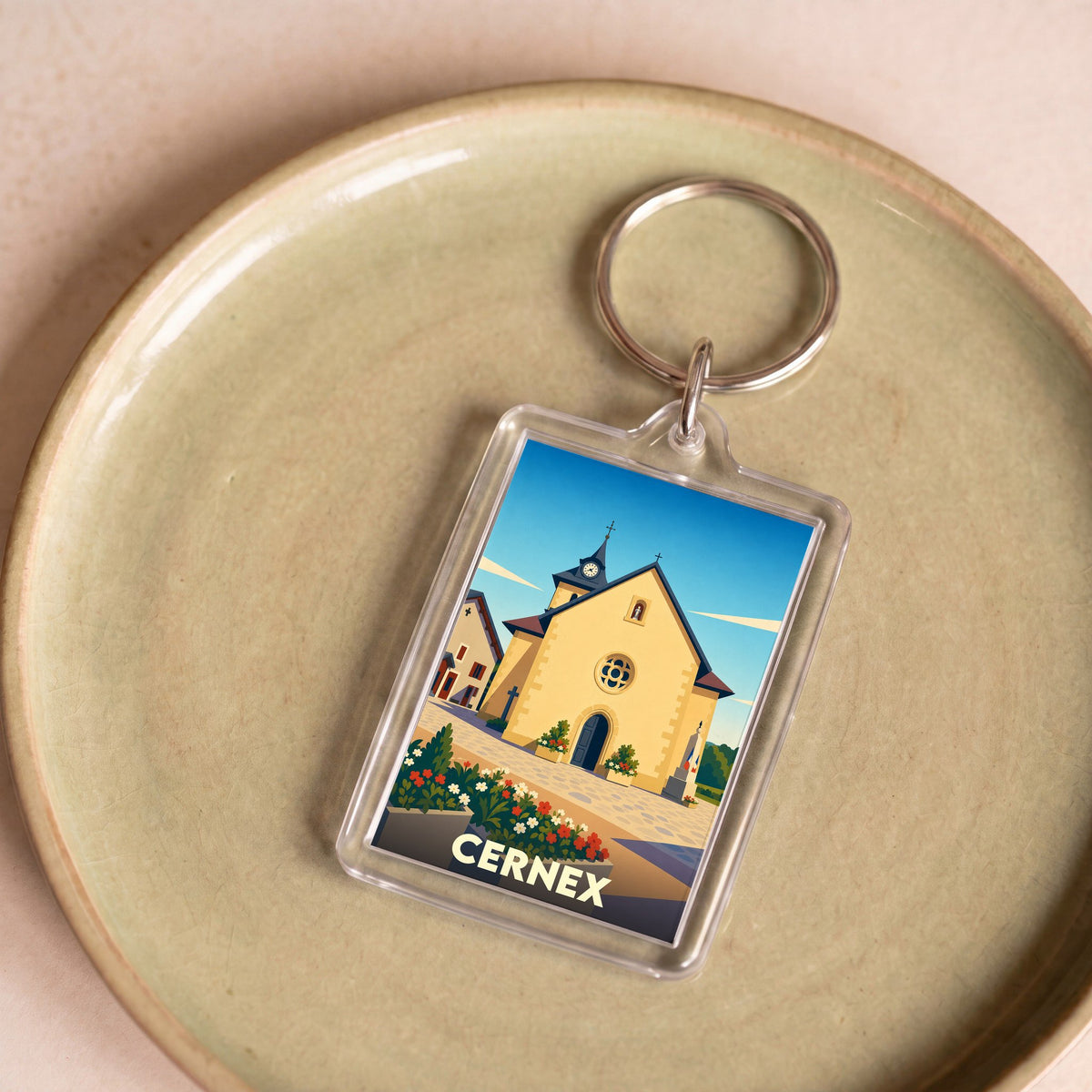 Porte-clés souvenir de la ville de Cernex avec une illustration stylisée de son église.