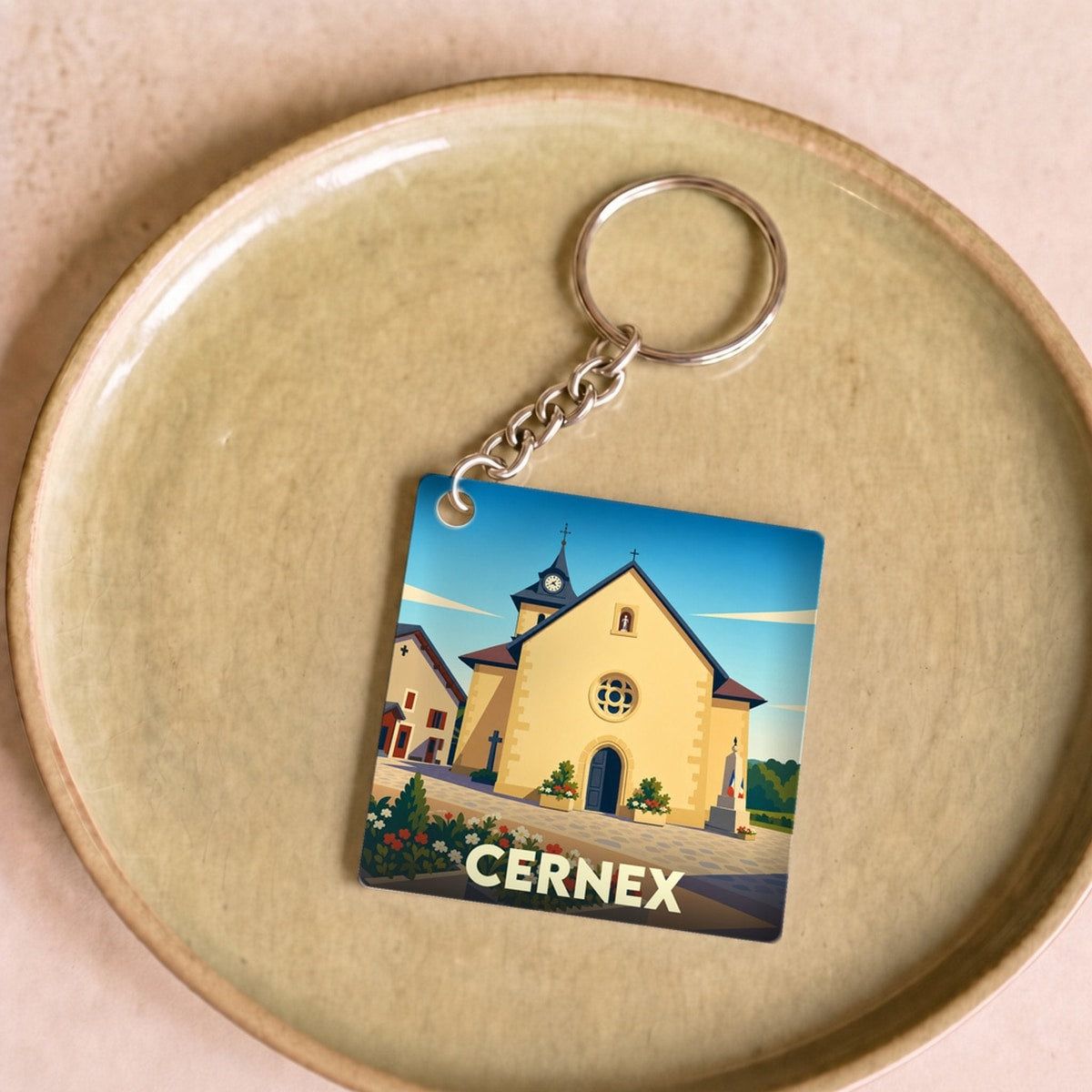 Porte-clés souvenir de la ville de Cernex avec une illustration stylisée de son église.